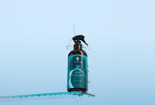 Bottle with a spray nozzle on a blue background