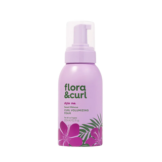 Purple bottle of 'flora & curl' foam with floral design on a white background