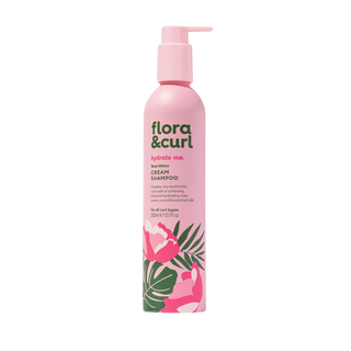Pink shampoo bottle with floral design on a white background