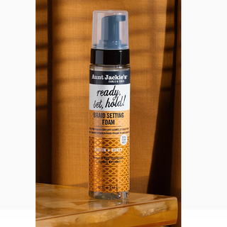 Aunt Jackie's Braid Setting Foam bottle on a wooden surface