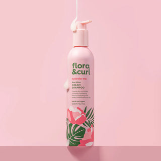 Flora & Curl shampoo bottle on a pink background