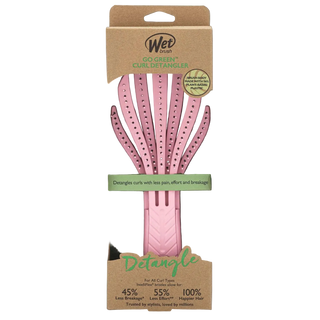 Pink detangling brush with brown packaging on a white background