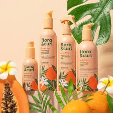 flora & curl hair care products with fruits and leaves on a peach background