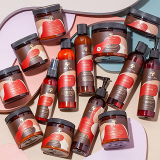 Assorted as i am hair care products with red and brown labels on a light pink background