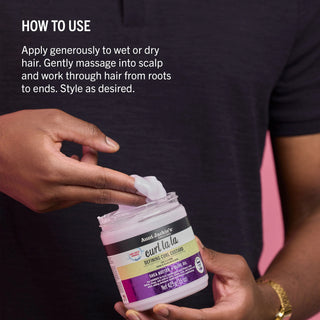Person holding a jar of hair product with application instructions displayed.