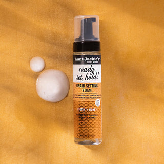 Aunt Jackie's braid setting foam bottle on a textured yellow background