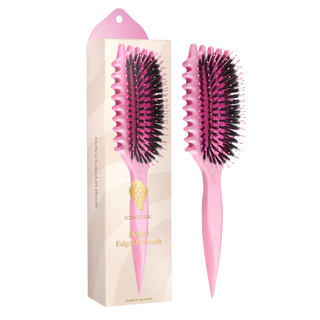 Pink hairbrush with black bristles next to its packaging on a white background