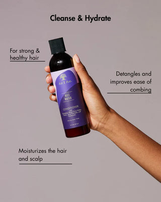 Hand holding a bottle of conditioner with text about hair care benefits on a gray background