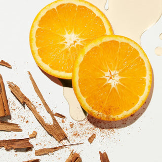 Sliced oranges with cinnamon sticks on a light background