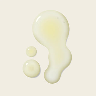 Three droplets of a light beige liquid on a beige background