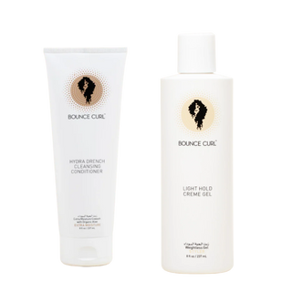 Bounce Curl haircare set featuring a white tube of Hydra Drench Cleansing Conditioner and a white bottle of Light Hold Creme Gel, both with the brand's signature black silhouette logo on a gold circle.