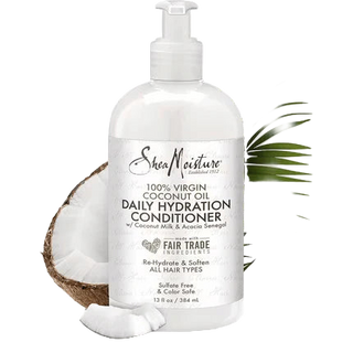 Shea Moisture coconut oil conditioner bottle with a coconut half and leaves on a white background