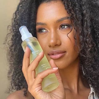 Woman holding a bottle of boucleme hair oil